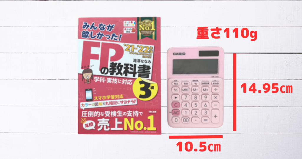 FP3級のカラフル電卓のサイズ。教科書と並べるとサイズがわかると思います。手のひらサイズでちょうどいい大きさです。