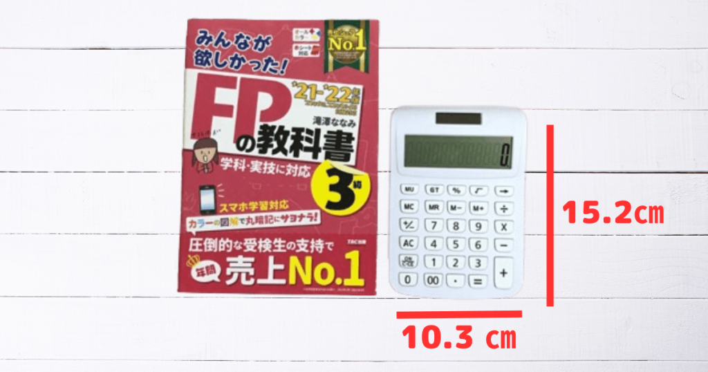 FP3級試験に使えるか検証するためのダイソーの300円の電卓とみんほしのテキスト。サイズの比較。ダイソーの電卓は手のひらサイズで扱いやすい大きさ。12桁。